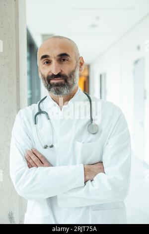Male doctor standing with arms crossed in the hospital Stock Photo - Alamy