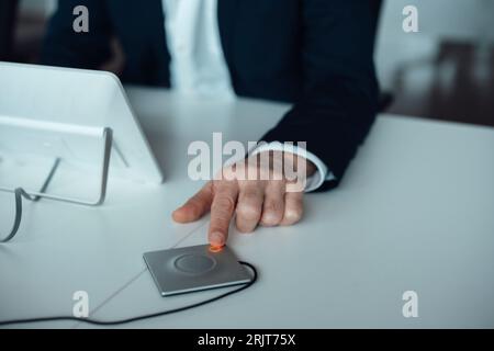 Hand of businessman pushing button at desk Stock Photo