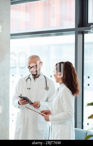 Happy doctors having discussion over tablet PC Stock Photo