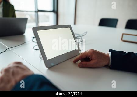 Businessman with tablet PC at desk Stock Photo
