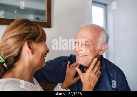 Happy senior woman embracing and having fun with man in cafe Stock Photo