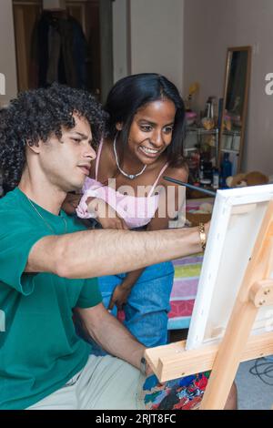 Smiling couple painting on canvas at home Stock Photo