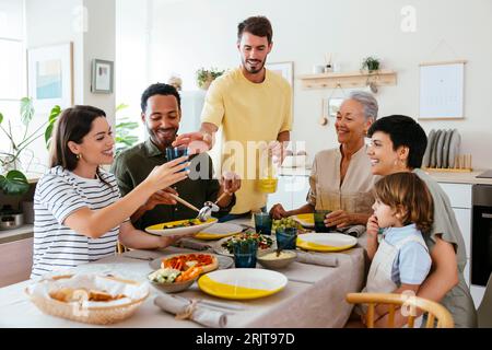 Happy family spending leisure time having lunch in kitchen Stock Photo