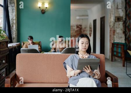 Young businesswoman working on tablet PC in cafe Stock Photo