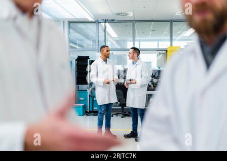 Technicians discaussing in work meeting at electronics factory Stock Photo
