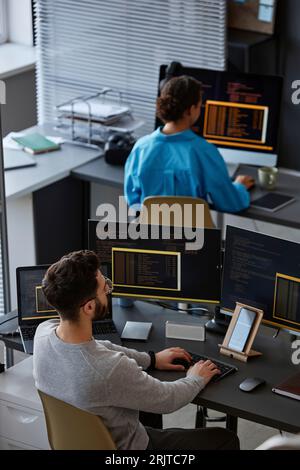 Computer programmers working on desktop PC at desk Stock Photo