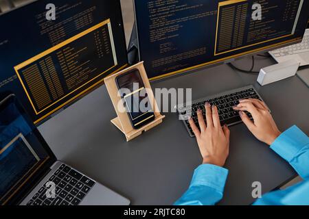 Hands of computer programmer typing on keyboard at desk Stock Photo