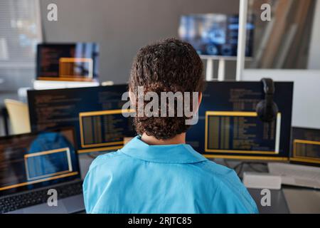 Young computer programmer working on desktop PCs Stock Photo
