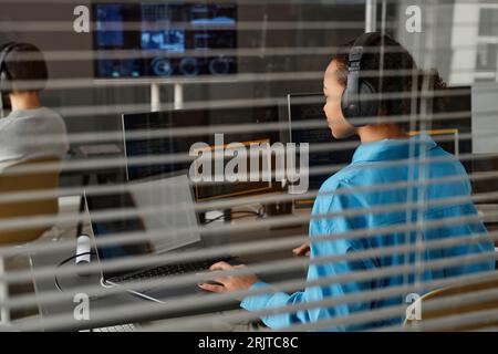 Young computer programmer working on desktop PC and laptop in office Stock Photo