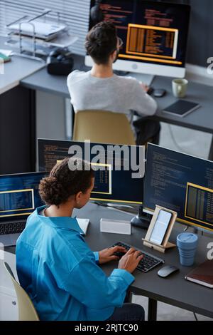 IT professionals working on desktop computers at desks Stock Photo