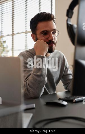 Thoughtful IT professional using desktop computer in office Stock Photo