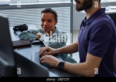 Smiling IT professional with colleague working on computer in office Stock Photo