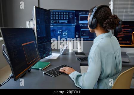 Computer programmer coding and working on desktop PC at desk Stock Photo