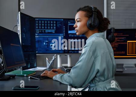Young computer programmer coding and working on desktop PC at desk Stock Photo