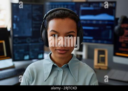 Young IT professional wearing wireless headphones in front of computers Stock Photo