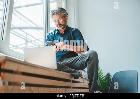 Businessman using smart phone and working at office Stock Photo