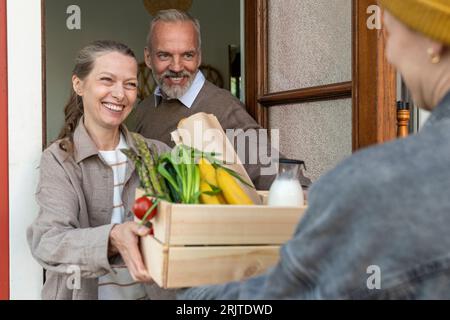 Happy mature couple receiving groceries via home delivery Stock Photo