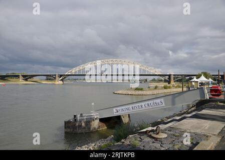 View of the Waal bridge. Inland shipping vessel sails under the Waal bridge; seen from the Waal quay in Nijmegen Stock Photo