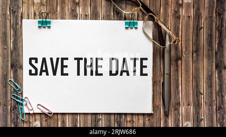 Text save the date on white paper on wooden background ,business concept Stock Photo