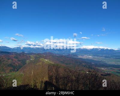 View of Gorenjska region of Slovenia with the hills of Skofja Loka in front, town of Kranj and Sorsko polje Kamnik Savinja alps with the peaks covered Stock Photo