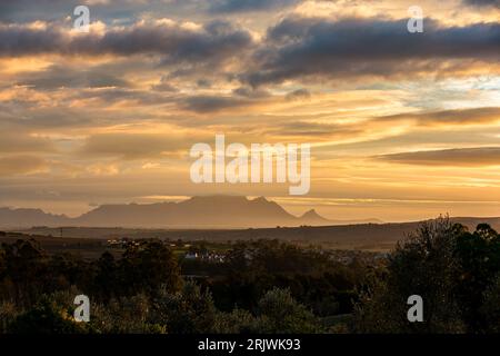 Golden sunset of wine region Stellenbosch Blauwklippen area with clouds and Table Mountain in distance wine travel tourism South Africa Stock Photo