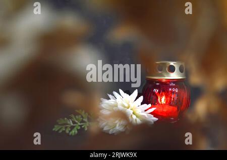 Burning grave candle lantern and chrysanthemum flower Stock Photo