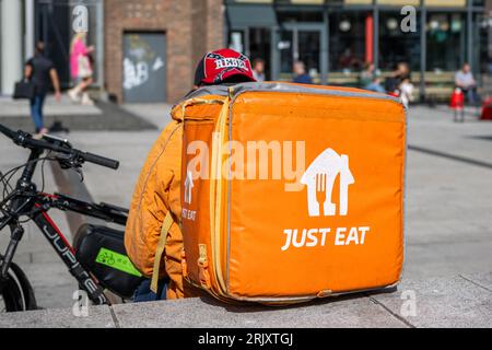 Just Eat delivery rider with bicycle taking a break in Dublin, Ireland. Stock Photo