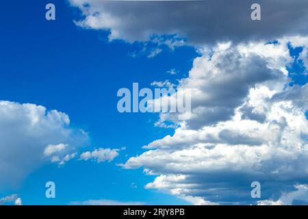 Vibrant blue sky filled with thick, white cumulus clouds creating a picturesque and dynamic cloudscape. Stock Photo