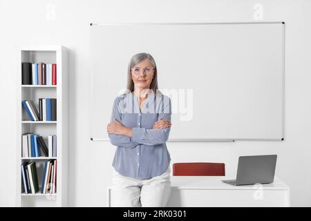 Portrait of professor near whiteboard in classroom Stock Photo