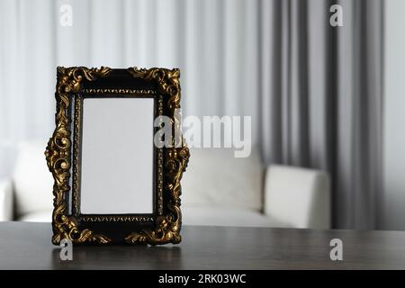 Beautiful vintage empty frame on wooden table, space for text Stock Photo