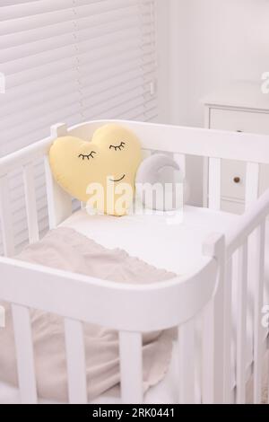 Comfortable crib with pillows in baby's room, closeup. Interior design Stock Photo