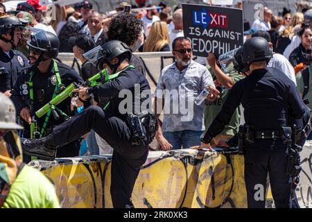 Los Angeles, California, USA. 22nd Aug, 2023. LAPD officers climb over a barricade to establish a skirmish line against an unpermitted 'Leave Our Kids Alone' march in downtown. (Credit Image: © Jacob Lee Green/ZUMA Press Wire) EDITORIAL USAGE ONLY! Not for Commercial USAGE! Credit: ZUMA Press, Inc./Alamy Live News Stock Photo