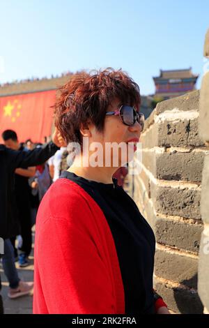 Qinhuangdao City, China - October 4, 2018: A lady in red plays on the Great Wall, Qinhuangdao City, Hebei Province, China Stock Photo