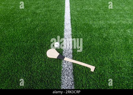 Hurling bat and sloitar on green grass. Horizontal sport theme poster ...