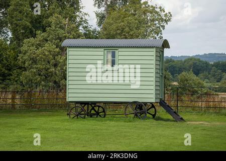 old vintage  green shepherds hut with countryside in the background Stock Photo