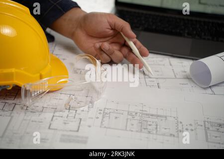 Man, architect, and engineer work discussing tools and construction concepts on a building site with blueprints for a professional construction job an Stock Photo