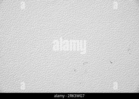 White wall or table texture for background. Close-up photo of white dirty stucco textured indented surface. Stock Photo