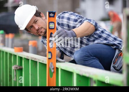 workman using spirit level on outdoor site Stock Photo