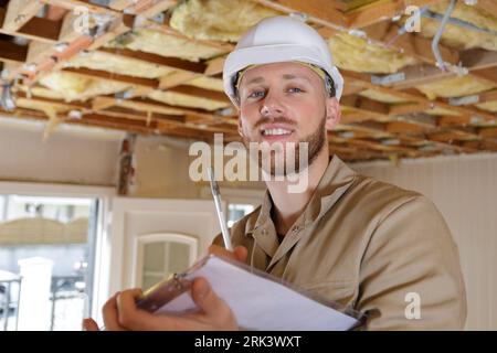 happy builder thinking about something indoors Stock Photo