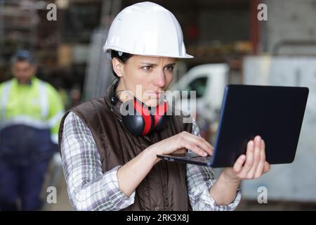 female engineer using programming software on laptop Stock Photo