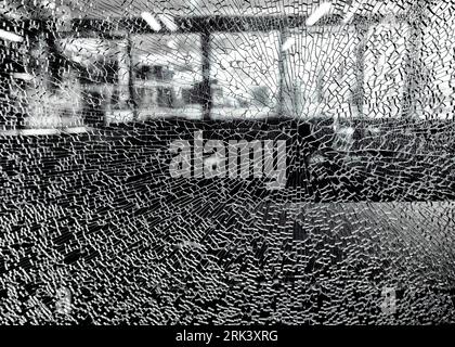 A black and white image of smashed/shattered sheet of safety glass, smashed but still intact, with a point of impact Stock Photo