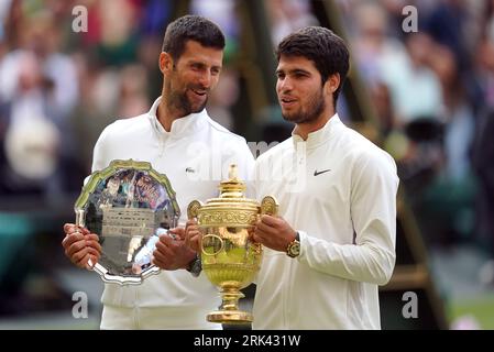 File photo dated 16-07-2023 of Carlos Alcaraz with the Gentlemen's Singles Trophy, alongside Novak Djokovic with the runners up plate/trophy. The US Open, the final grand slam of the year, begins on Monday. Here, the PA news agency looks at the talking points ahead of Flushing Meadows. Issue date: Thursday August 24, 2023. Stock Photo