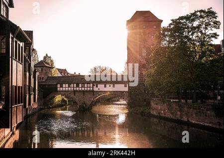 Sunset over old medieval bridge over Pegnitz river in Nuremberg, Germany. Hangman's Bridge. Stock Photo