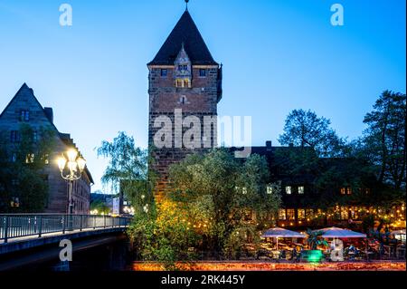 Old tower and cafe near river in the evening in Nuremberg, Germany Stock Photo