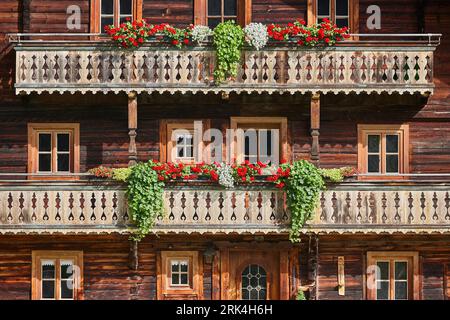 Traditional rustic wooden house decorated with flowers in Austria Stock Photo