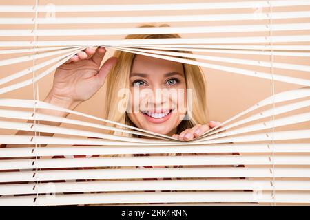 Portrait photo of peering funny woman jalousie office have fun playing hiding looking you peek isolated over beige color background Stock Photo