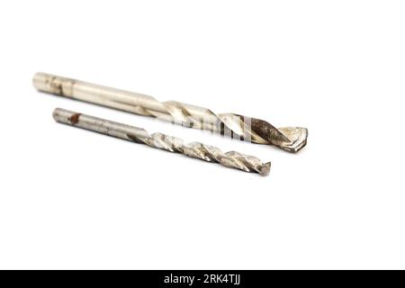 A closeup of two stainless steel drill bits resting on a white background Stock Photo