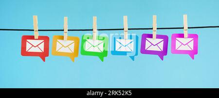 Email marketing newsletter and mailing list web and Internet concept with white e-mail icon and symbol on colorful paper speech bubbles. Stock Photo
