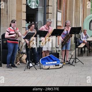Group of saxophonists playing in Winchester Town Centre Stock Photo