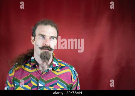 Hipster man with mustache looking to side with expression of doubt and confusion Stock Photo
